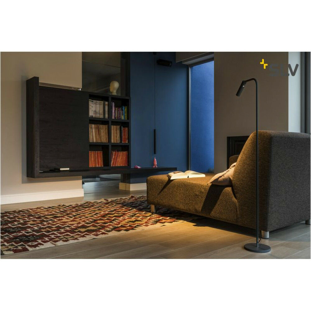 hosszúkás formájú hajlítható design fekete állólámpa sötét bútorokkal berendezett nappaliban olvasókanapé mellett, ötletek férfiaknak